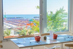 a dining room with a view of the beach at Hotel Nobel in Gabicce Mare +59 photos