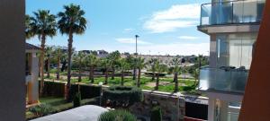 a view of a park with palm trees and a building at Royal Park Green Spa in Orihuela Costa