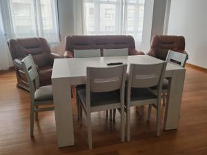 a white dining room table with chairs and a couch at Apartamentos Shalom Ribadeo in Ribadeo