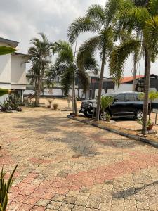 a car parked in front of a building with palm trees at Mobile Unique Apt in Ikeja