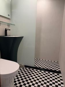 a bathroom with a toilet and a black and white checkered floor at Fei Li Jin Hotel in Kenting +16 photos