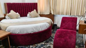 a bedroom with two beds with a red headboard at Hotel New Vinayak in Ahmedabad