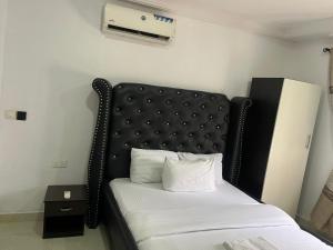 a bed with a black headboard in a room at Mobile Unique Apt in Ikeja +18 photos