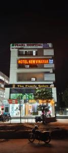 a building with a motorcycle parked in front of it at Hotel New Vinayak in Ahmedabad