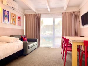 a bedroom with a bed and a table and a dining room at Mount Eden Motel in Auckland