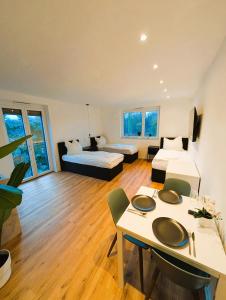 a room with two beds and a table with chairs at Montelio Living in Ettlingen