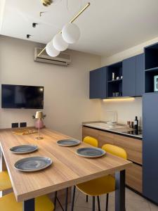 a dining room with a wooden table and yellow chairs at Casa Merano Residence & Restaurant Bibione - New suites in Bibione
