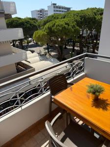 a wooden table and chairs on a balcony at Casa Merano Residence & Restaurant Bibione - New suites in Bibione