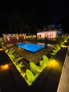 a night view of a swimming pool with lights at Aagneyam villa in Kozhikode