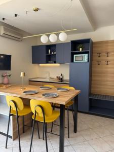 a kitchen with a wooden table and yellow chairs at Casa Merano Residence & Restaurant Bibione - New suites in Bibione