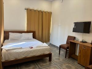 a bedroom with a bed and a tv and a chair at Aagneyam villa in Kozhikode