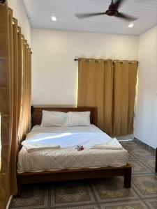 a bed in a bedroom with a ceiling fan at Aagneyam villa in Kozhikode +2 photos