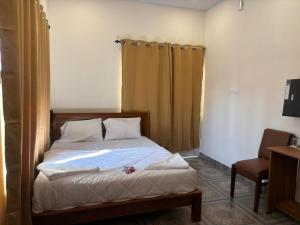 a bedroom with a bed and a chair at Aagneyam villa in Kozhikode