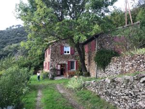 an old stone house with a child walking past it at La Bellevue in Valleraugue