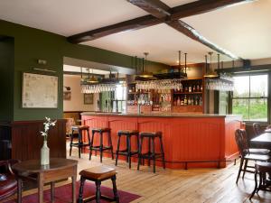 a bar in a restaurant with chairs and tables at The Brackenrigg Inn in Watermillock
