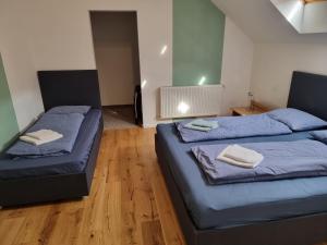 two beds in a room with blue sheets and towels at Munich Residence in Cristian
