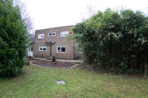 a brick house with a cross in front of it at The Laurels - Wifi, Parking, 4 Bedrooms, Gatwick in Crawley