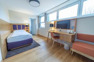 a bedroom with a bed and a desk with a computer at Dialoghotel Eckstein in Zug +27 photos