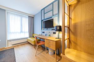 a hotel room with a desk and a tv at Dialoghotel Eckstein in Zug