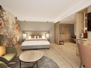 a hotel room with a bed and a couch at Churfürstenhof Wellnesshotel in Bad Birnbach +50 photos