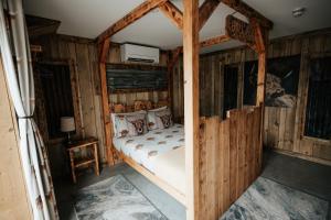 a bedroom with a bed in a room with wooden walls at The Moo-tel at Moody Meadows in Aberaeron