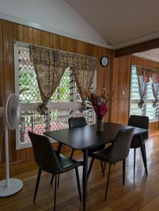 a dining room with a table and chairs and a clock at Naghoniara Airport Transit in Honiara