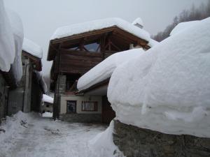 une pile de neige sur le côté d'une maison dans l'établissement B&B A Pankeo, à Valtournenche