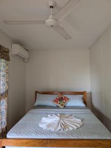 a bed in a room with a ceiling fan at Naghoniara Airport Transit in Honiara