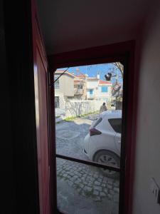 a view of a car through a glass door at Kıymet Aydogdu in Alaçatı