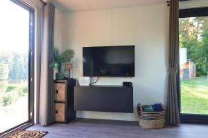 a living room with a flat screen tv on a wall at Tinyhouse Seeträumchen direkt am See mit Terrasse für 4 in Bodenwöhr