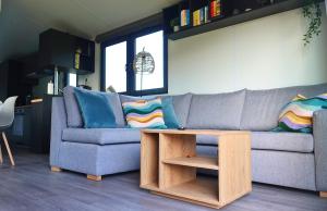a living room with a couch and a coffee table at Tinyhouse Seeträumchen direkt am See mit Terrasse für 4 in Bodenwöhr