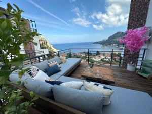 a balcony with a couch and a view of the ocean at Sweet Home Turunc - Sea View Suites with One Bedroom in Turunç