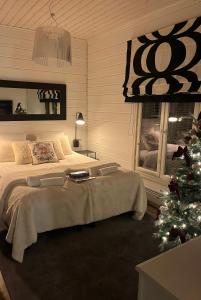a bedroom with a bed and a christmas tree at Apartment Suutarintie - Authentic Lappish experience by the River in Rovaniemi