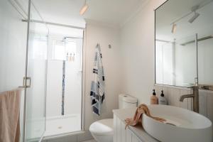 a white bathroom with a sink and a toilet at Lousha Bach Dolphin Heads in Eimeo