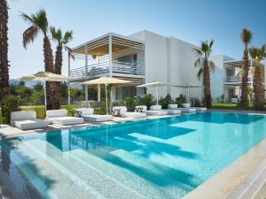 a villa with a swimming pool and palm trees at Flamm Residences in Bodrum City