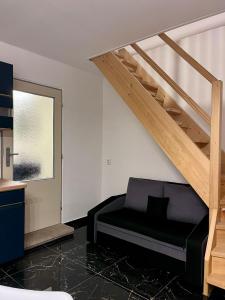a living room with a black couch and stairs at ZANIK Cozy Haven in Prague +11 photos