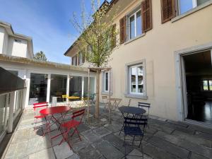 a patio with red and blue tables and chairs at Dialoghotel Eckstein in Zug