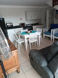 a kitchen and a living room with a table and chairs at J&B Tuiste in Reebok