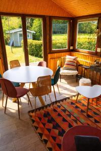 a screened in porch with tables and chairs and windows at Le Petit Idéal in Leykaul +20 photos