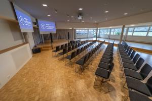 a conference room with chairs and a stage in the middle at Dialoghotel Eckstein in Zug