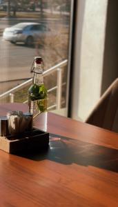 a bottle of beer sitting on a wooden table at Home Inn Hotel in Almaty
