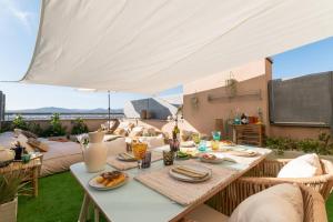 a table with plates of food on a patio at Penthouse with Private Terrace & Pool Access in Cornellà de Llobregat