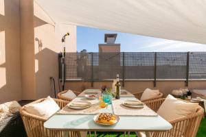 a table with a plate of food on a patio at Penthouse with Private Terrace & Pool Access in Cornellà de Llobregat