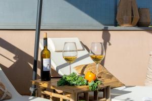 a table with two glasses of wine and vegetables at Penthouse with Private Terrace & Pool Access in Cornellà de Llobregat +32 photos