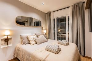 a bedroom with a bed with a mirror on the wall at NEW Refurbished Modern Apartment in Barcelona