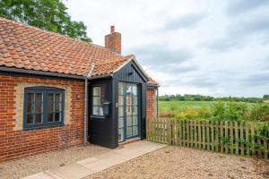 a brick house with a black door and a fence at 3 Bed in Snape oc-2wadd in Snape