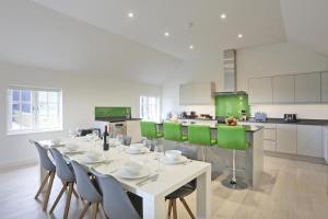 a dining room with a white table and green chairs at 3 Bed in Snape oc-2wadd in Snape