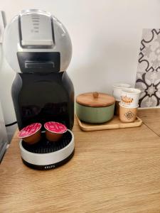 a coffee maker sitting on a table with cupcakes at Chalet Cosy avec option Jacuzzi in Saint-Genès-de-Fronsac