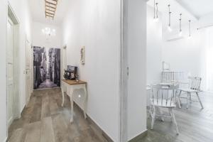 un pasillo con paredes blancas, mesa y sillas en Le Villanelle B&B, en Nápoles