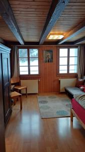 a large living room with a couch and windows at Familienzimmer mit Bergblick in Emmetten